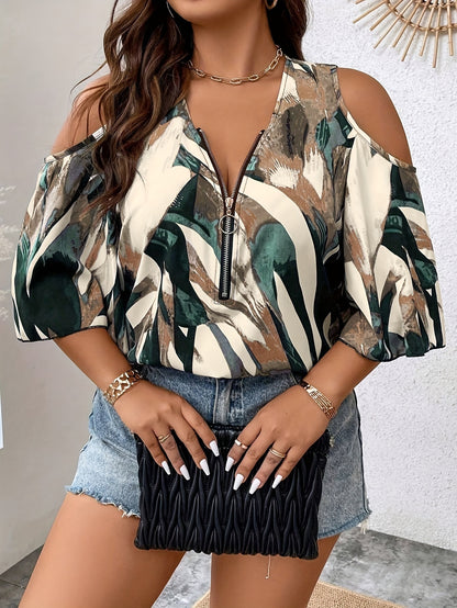 Woman wearing a patterned blouse with denim shorts and holding a black clutch.