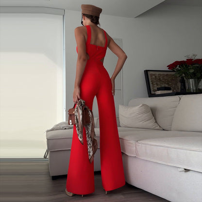 Woman in a red jumpsuit standing in a living room.